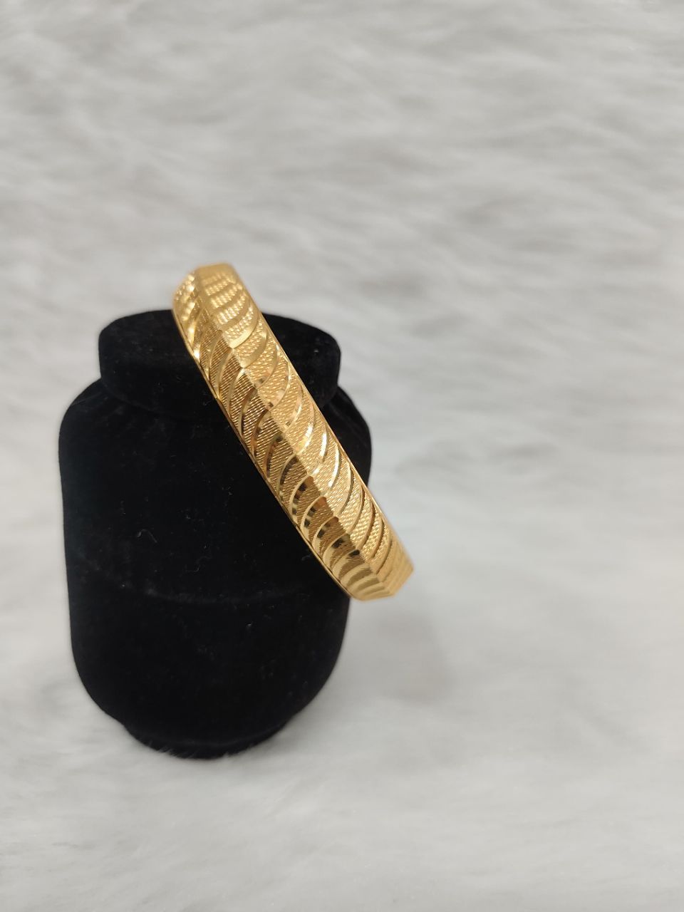 Gold-plated designer kada features a distinctive textured pattern along its entire surface view 3
